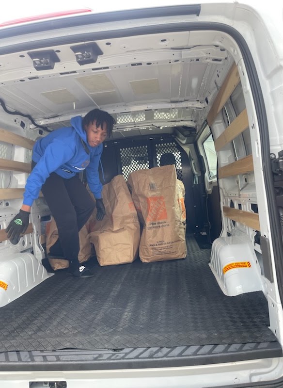Volunteer loading grocery bags into a van
